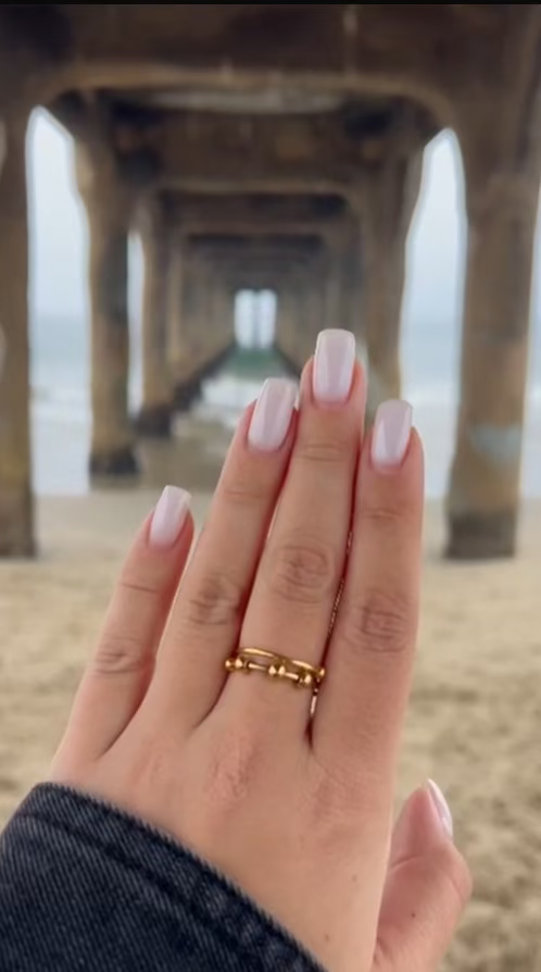 Hand with a gold ring on a blurred pier background